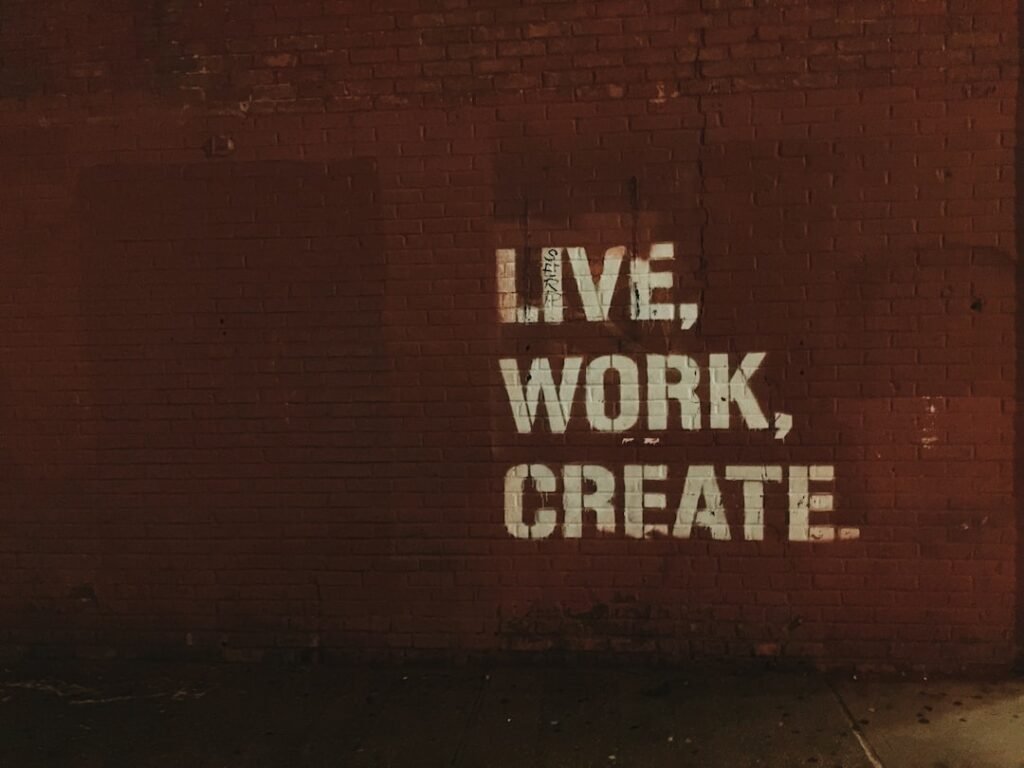 red brick wall with live, work, create. quote