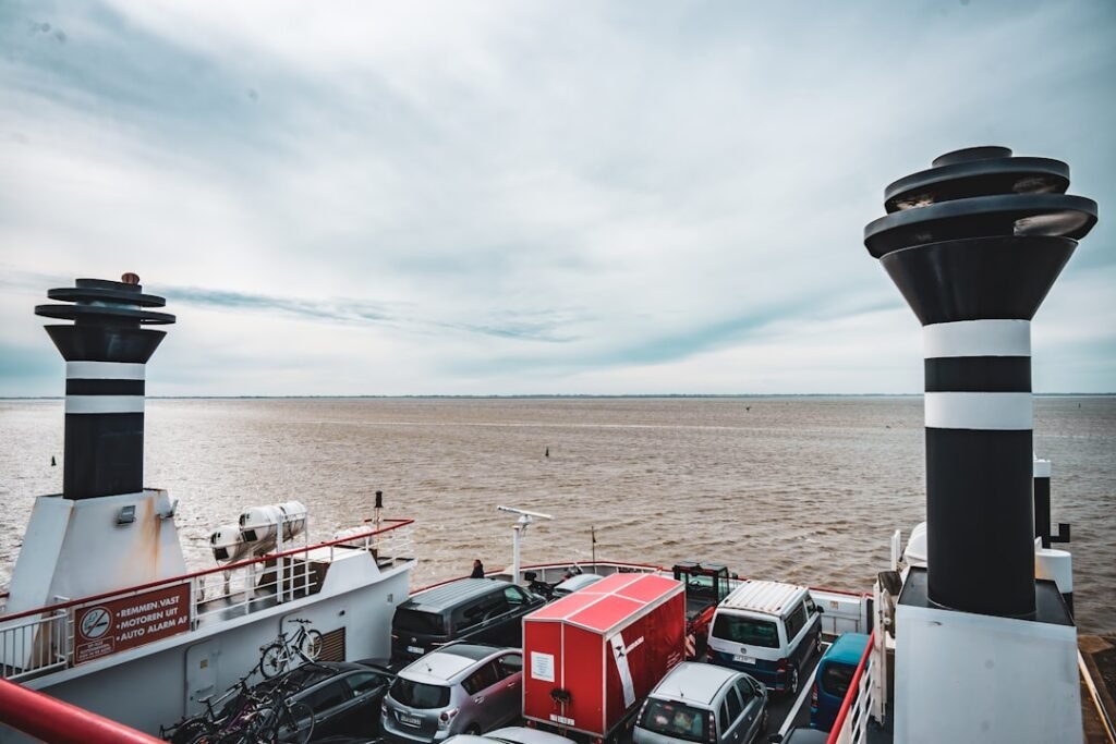 Cars and funnels on a ferry sailing on the ocean.